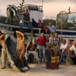 naked girl caught in net surrounded by fishermen